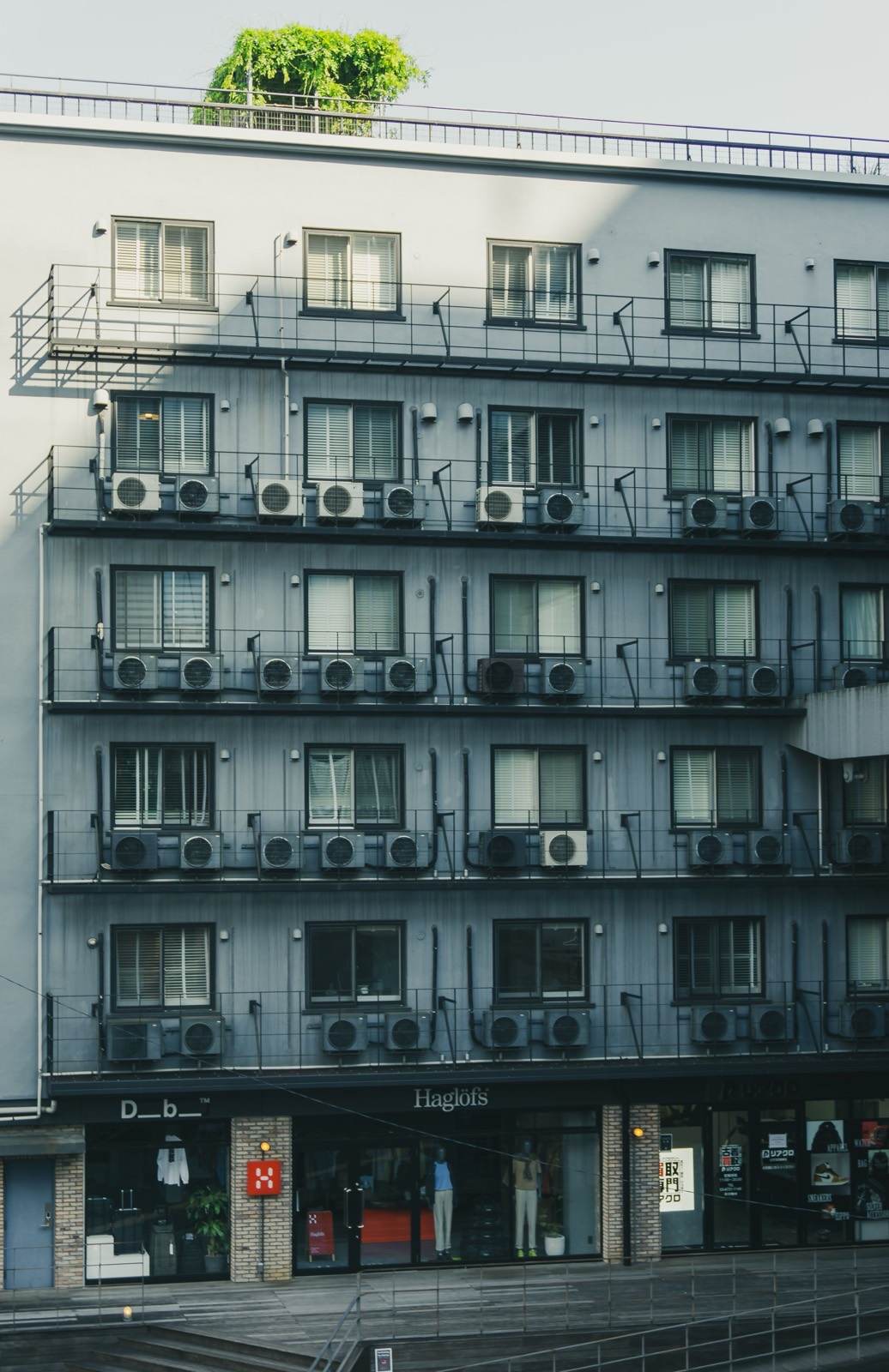 Apartment building facade with mini-split condenser units mounted on every balcony level